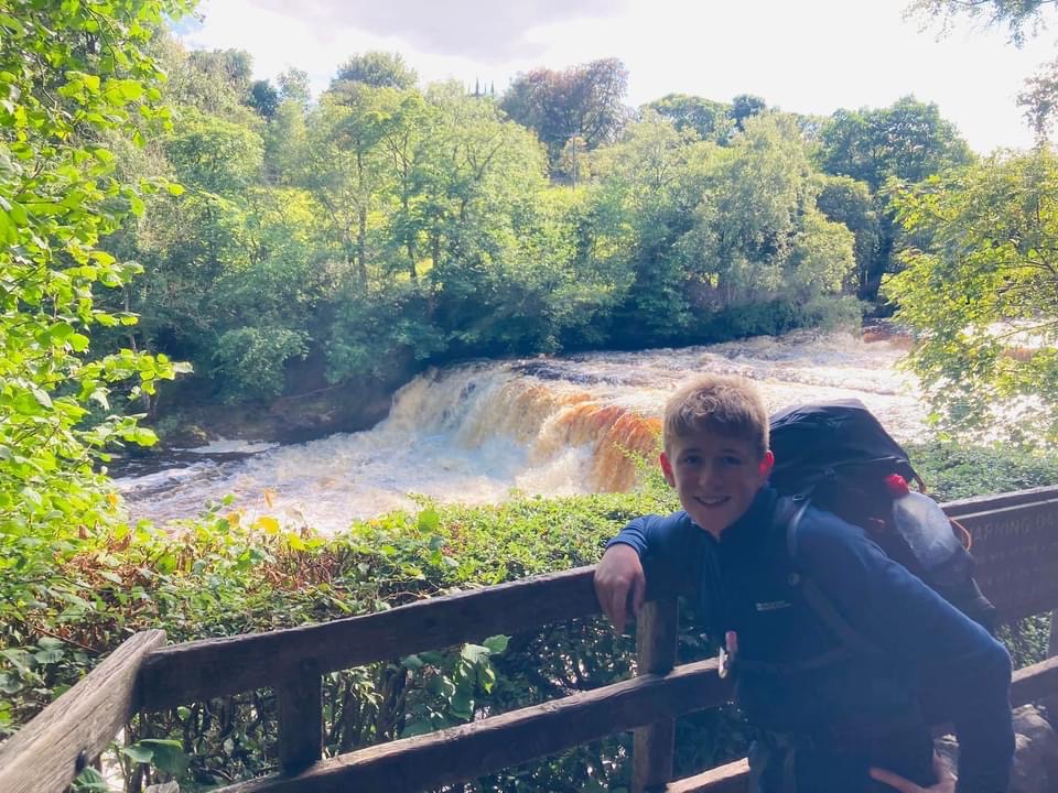 Boy by waterfall